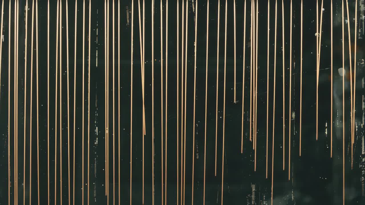 Abstract video background with vertical light streaks on a dark surface