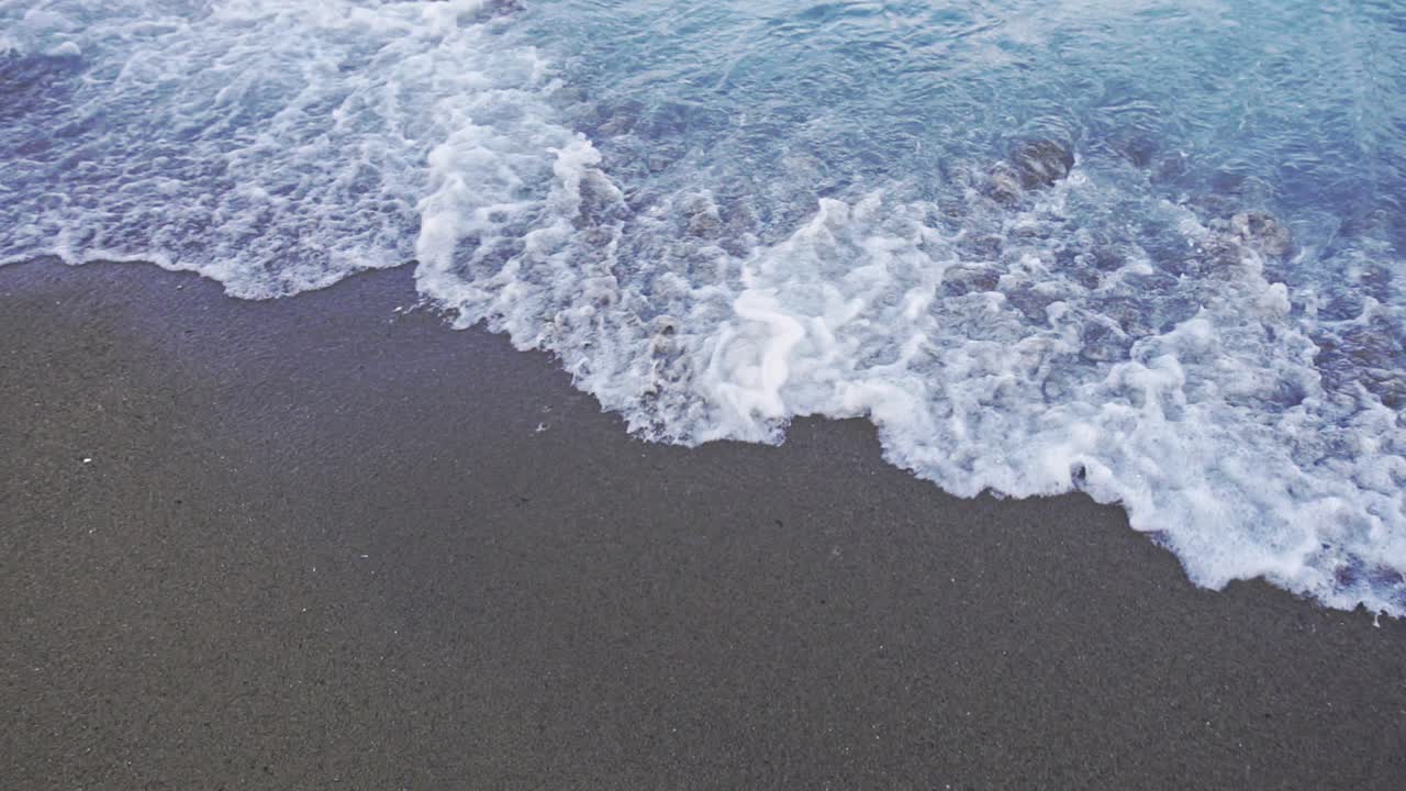 파도 가 있는 바다 물 근처 에 서 있는 여자 의 포브. 휴가 에 있는 해변 에 있는 여자