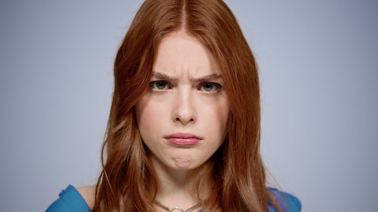 Gloomy girl looking at camera in studio. Disappointed woman posing indoors