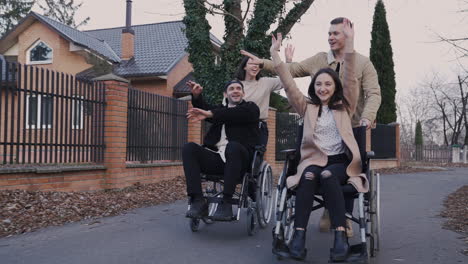 woman and man running with her disabled friends in wheelchair and having fun together 2