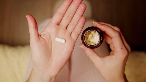 mujer con pastillas y frasco de pastillas