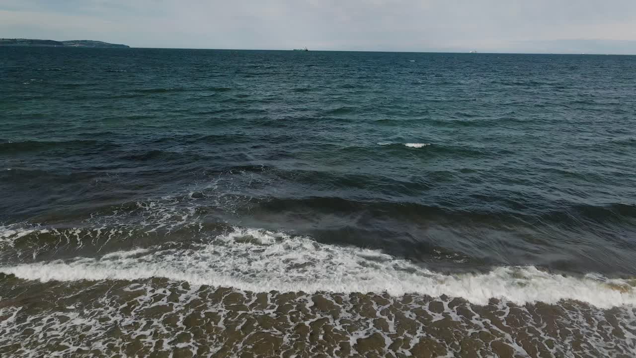 Vista aerea di onde che si infrangono sulla spiaggia, al rallentatore.