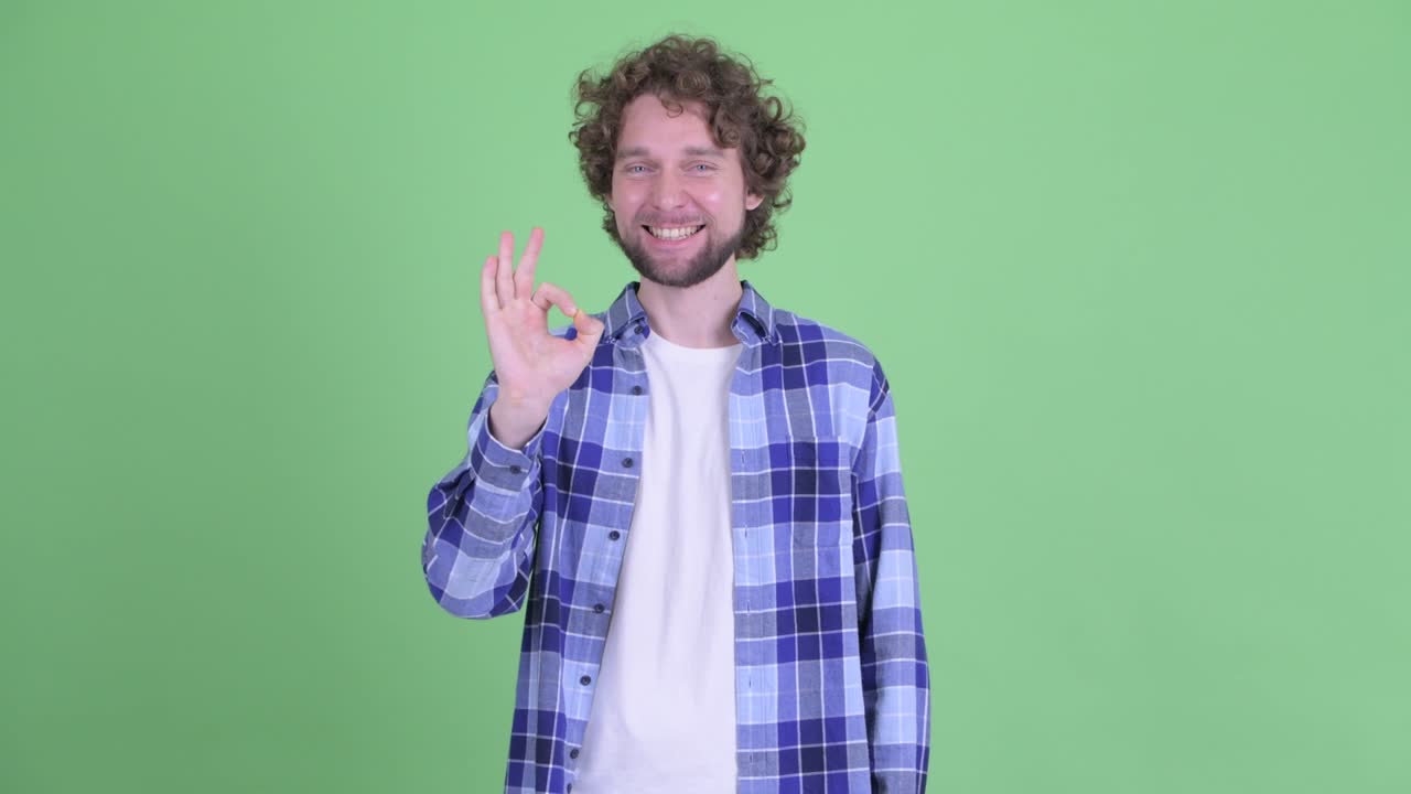 un joven guapo, barbudo y hipster con el cabello rizado.
