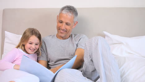 Smiling-girl-reading-a-book-with-her-father