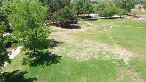 un dron en ascenso de un marcador de bandera colocado en el césped de un parque público