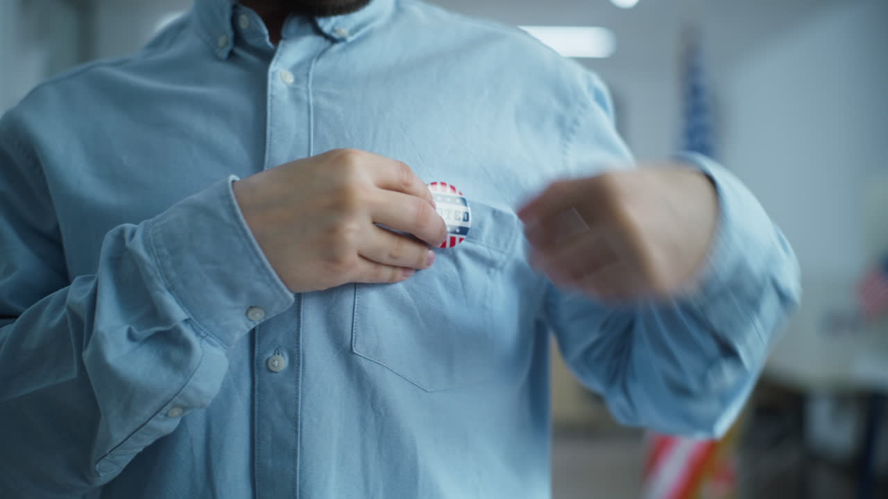 African American us Citizen Puts on Badge with Usa Flag Logo Close up of Anonymous African American Man or us Citizen Putting on Badge with Usa Flag Logo and Inscription i Voted Male Voter at Polling Station after Voting Election Day in the United States