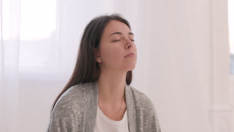 woman with closed eyes relaxing at home