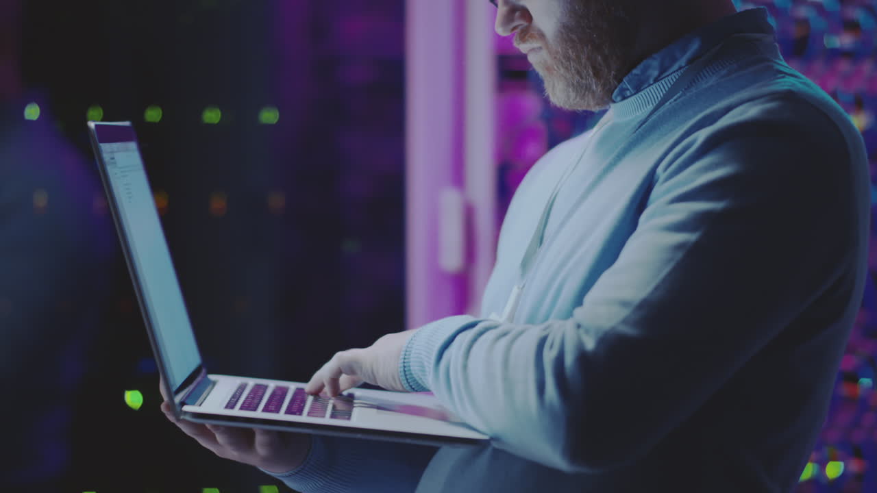 Man working on a laptop in a data center