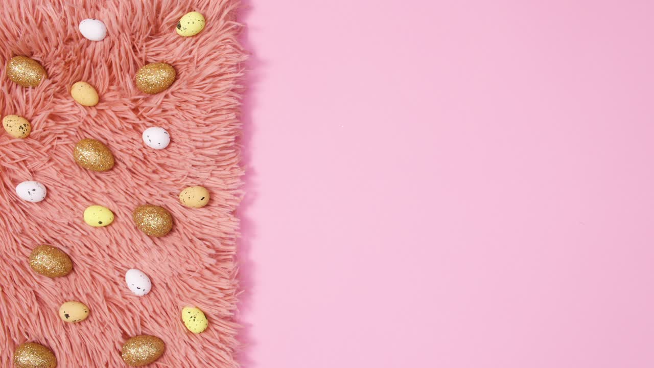 Golden eggs move on fur on pastel pink background. Stop motion flat lay