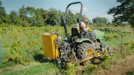 Ein-Bauer-Arbeitet-An-Einem-Kleinen-Traktor,-Der-In-Der-Nähe-Des-Weinbergs-Unkraut-Entwurzelt