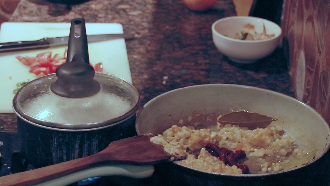 Adding spices and water on a pan as part of cooking homemade gravy sauce, candid daily chores and home life
