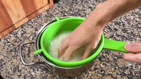 a hand washing rice in preparation for making onigiri - close up
