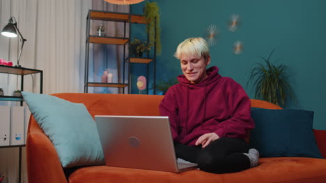 Woman-sitting-on-home-couch,-looking-at-camera,-making-video-conference-call-with-friends-or-family