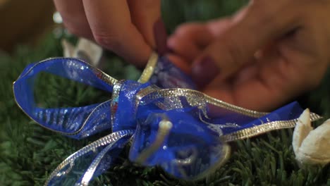 Woman-making-a-fir-Advent-wreath-for-Christmas-Eve-and-decorating-it-with-blue-ribbon,-diy-craft-decoration,-winter-traditions,-seasonal-holidays,-hands-close-up-shot