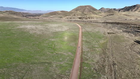 fotografía de un avión no tripulado de un coche conduciendo en un camino de tierra en willcox, arizona, fotografía aérea de seguimiento amplio