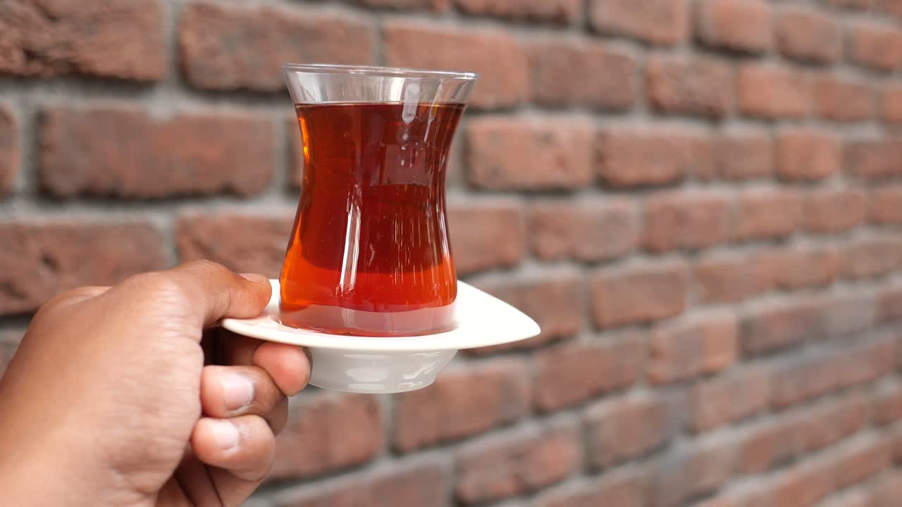 전통적인 터키 차 컵을 들고 있는 손