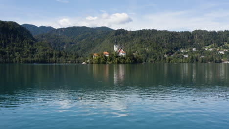 flying over calm waters of lake bled towards bled island in slovenia