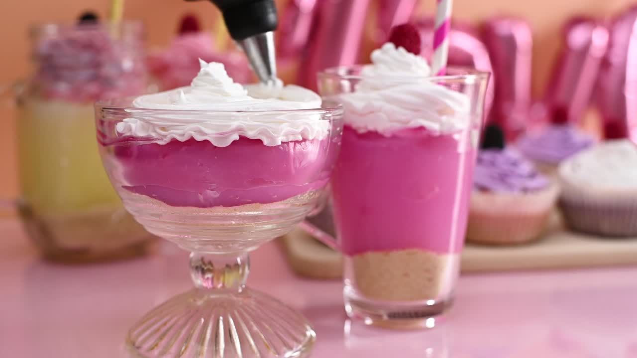 haciendo postres de fiesta dulces. decorando pudín de fresa en taza con crema blanca. cerca