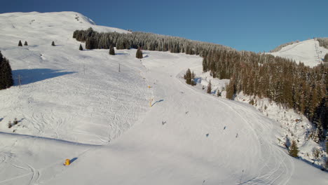 zona de esquí en saalbach-hinterglemm, austria durante el invierno - toma aérea de un dron