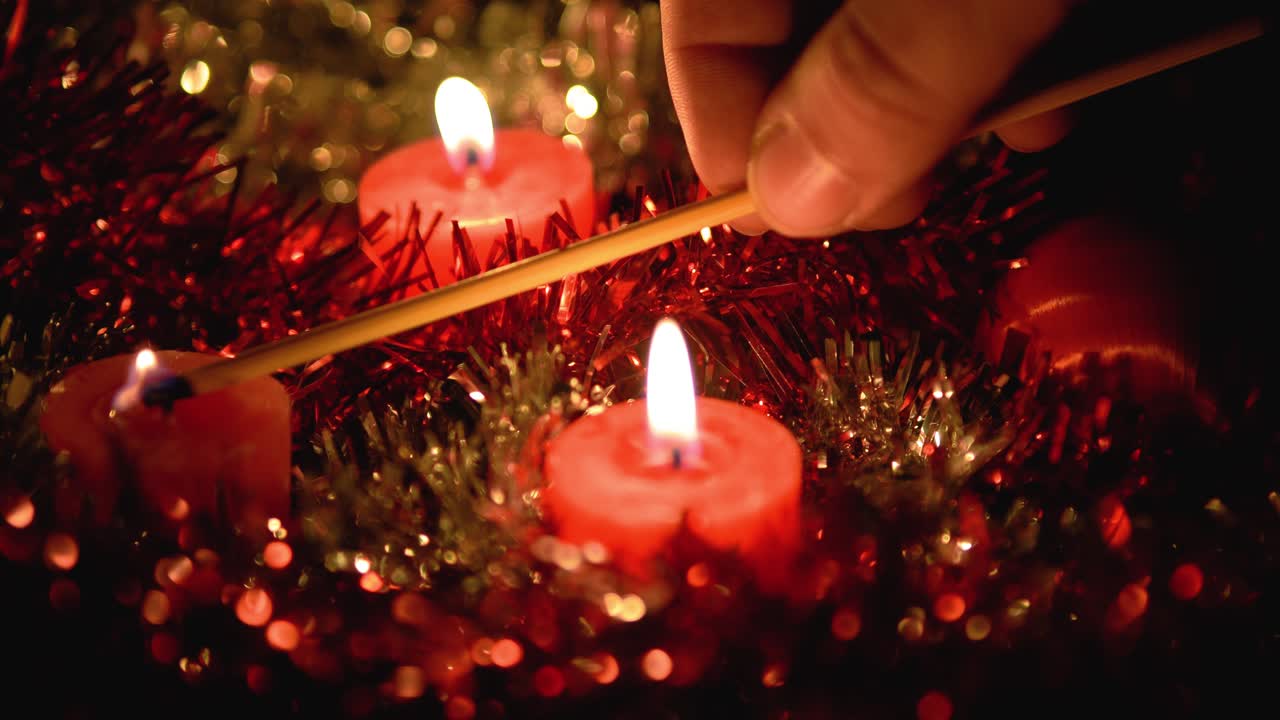 hermoso video de velas encendidas a mano y apagándolas con el golpe final, fondos brillantes hechos de decoración navideña
