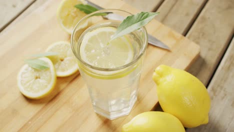 video of glass with lemonade and lemons on wooden board