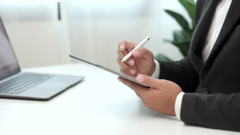 hombre de negocios que usa un lápiz estilográfico firmando un contrato en una tableta digital en el trabajo en la oficina en el interior. escriba a mano el acuerdo de negocios del contrato. firma electrónica en una computadora tableta.