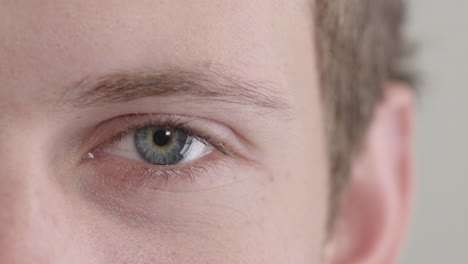 young-man-eye-opening-beautiful-blue-iris-looking-at-camera-macro-close-up