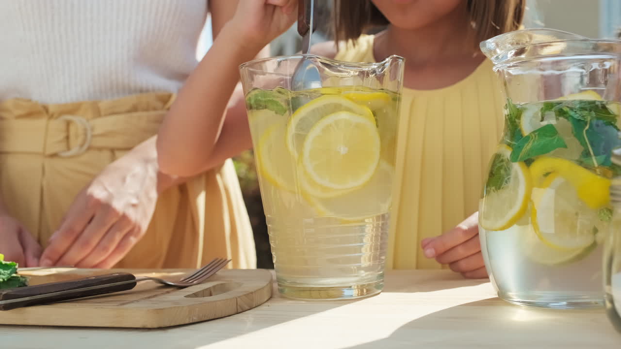 Girl Adding Mint To Homemade Lemonade