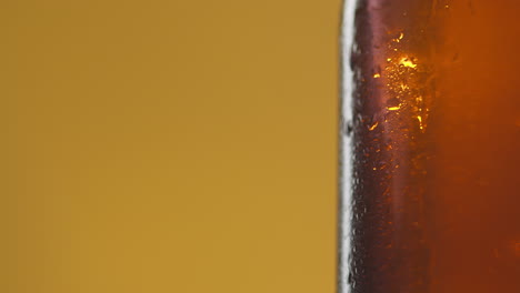 close up of condensation droplets on revolving bottle of cold beer or soft drink with copy space 1