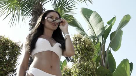 beautiful girl in a white bathing suit posing on the camera in slow motion