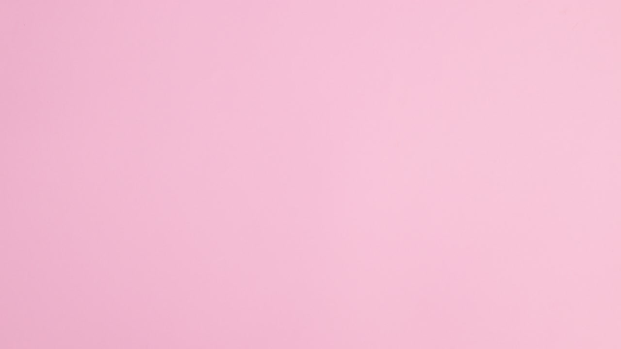 Summer beach bag, hat and accessories appear with copy space frame on pastel pink background. Stop motion flat lay