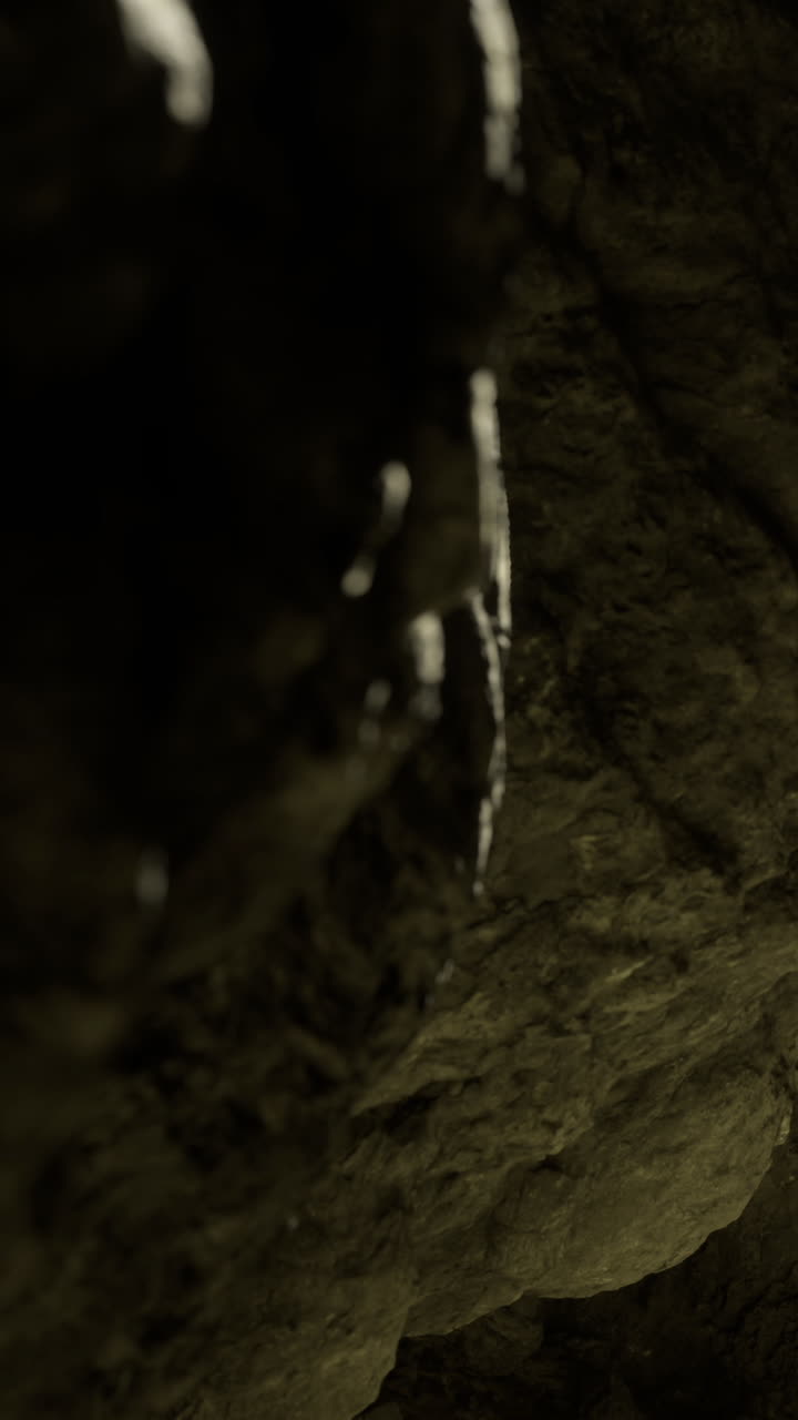 Acqua che gocciola dal soffitto di una grotta in un luogo sotterraneo buio di giorno.