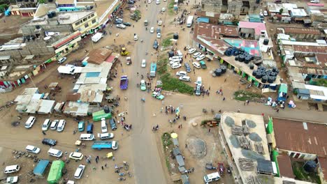 Aerial-view-of-cars-and-people-at-a-Open-Air-Market,-in-Africa---reverse,-drone-shot