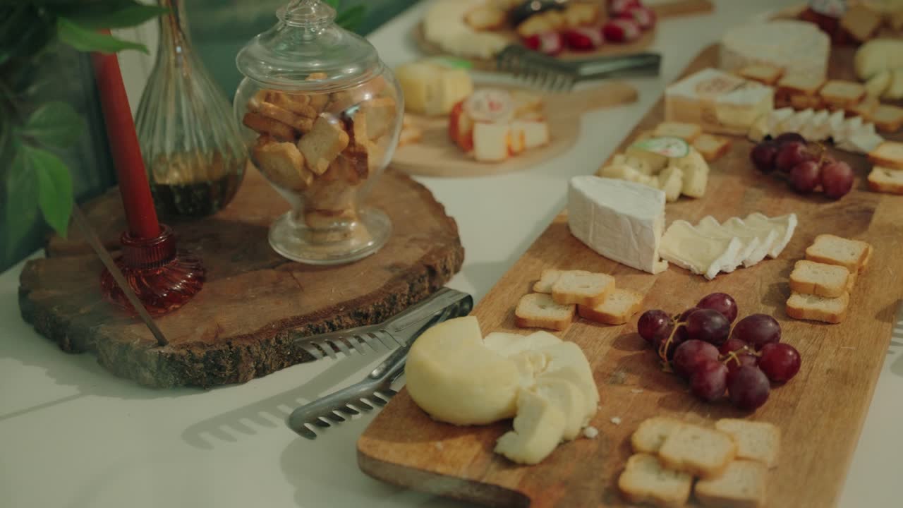 cheese platter with crackers grapes and soft lighting set on rustic wood for wedding buffet