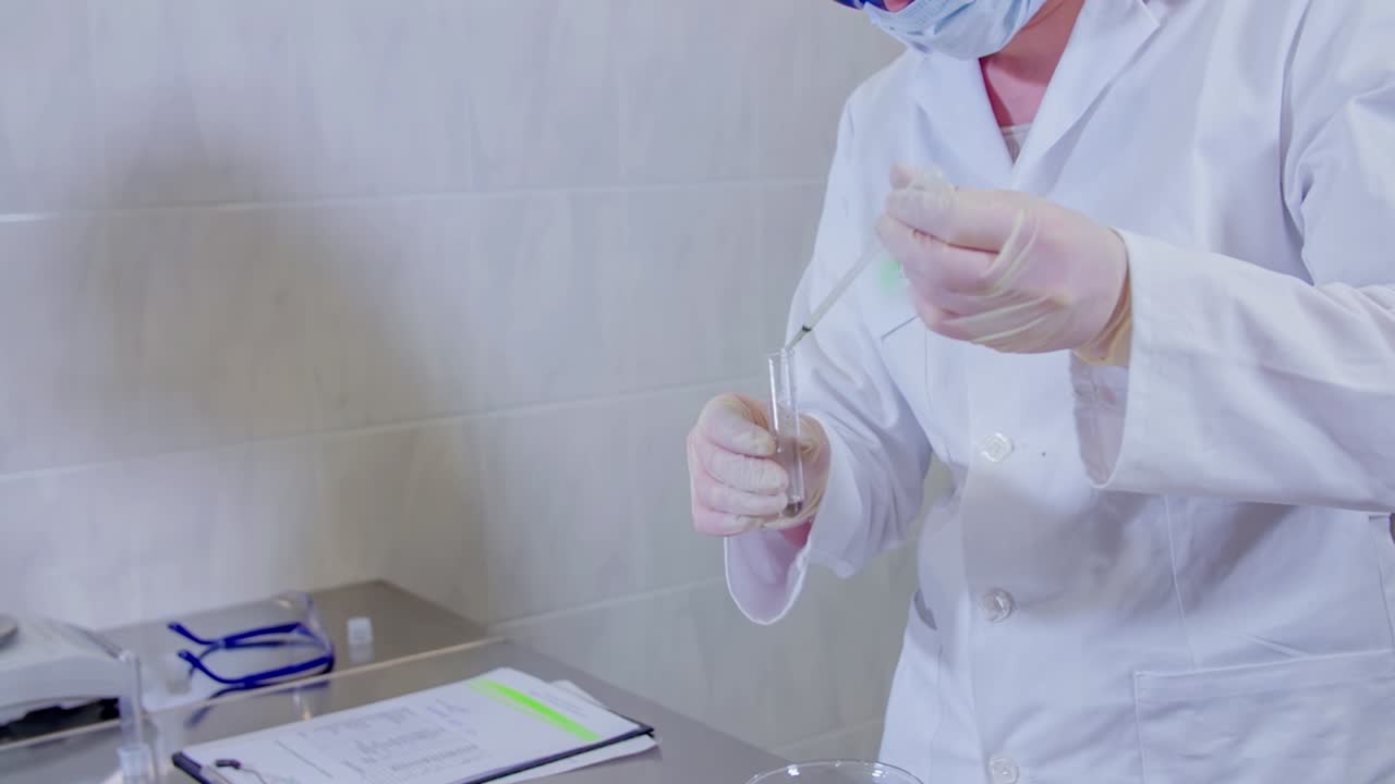 Scientist measuring and transferring test tube liquid at lab. Covid-19 research