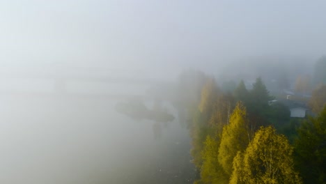 Vista-Aérea-De-árboles-De-Colores-Otoñales-A-Lo-Largo-De-Un-Río,-Brumoso,-Amanecer-De-Otoño-En-Los-Países-Nórdicos