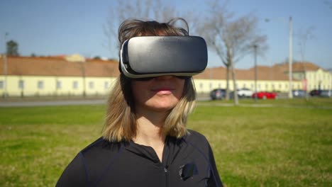 una chica deportiva sonriente con auriculares vr en el parque