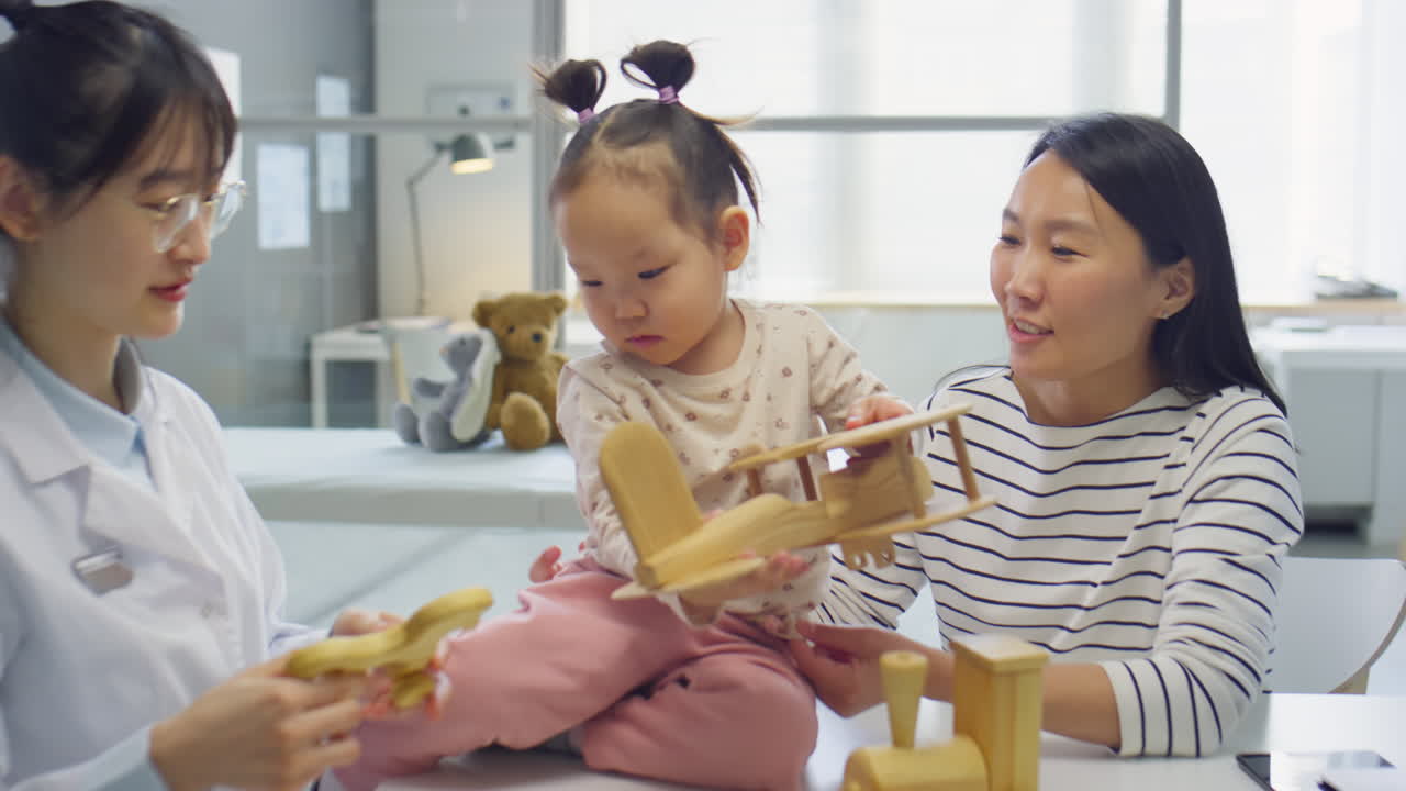 Asian Toddler Girl Playing with Toys in Medical Office