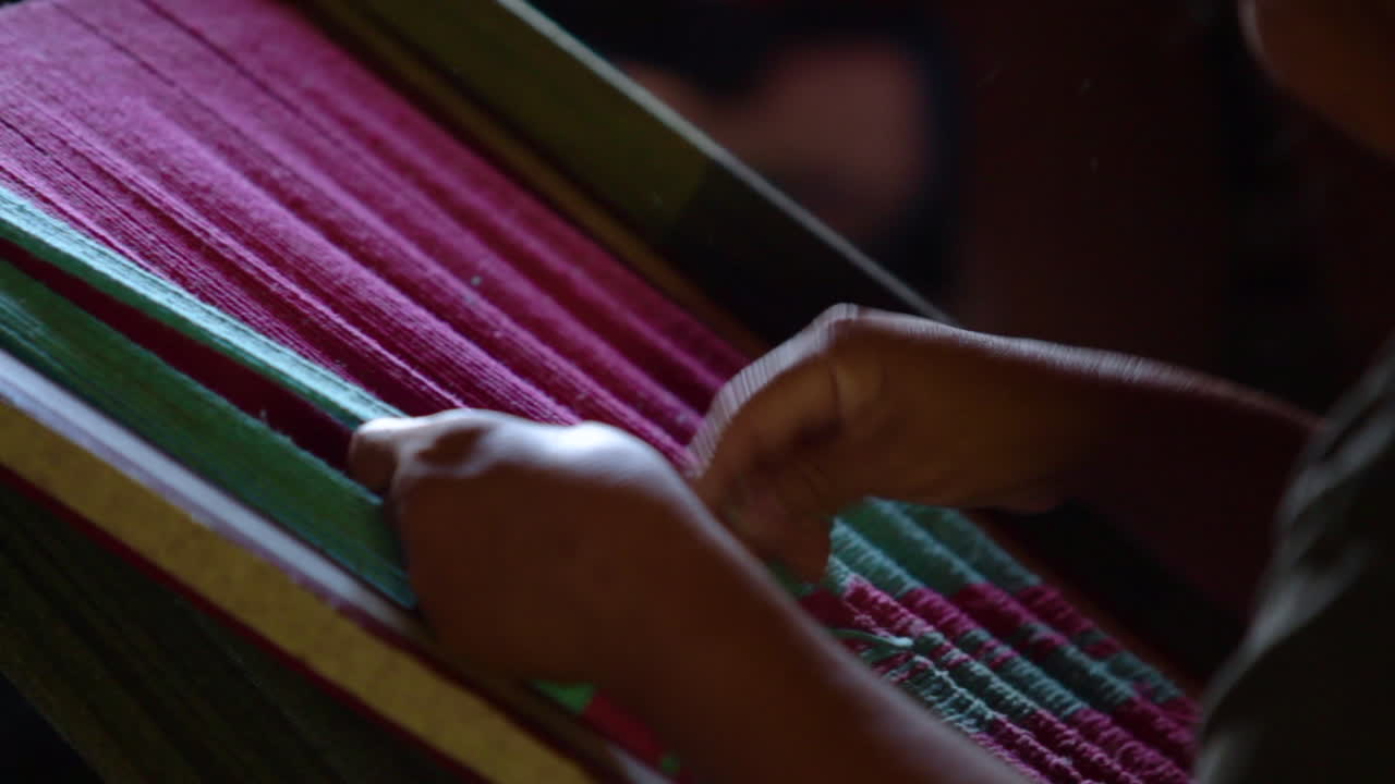 mujer indígena tejiendo una manta