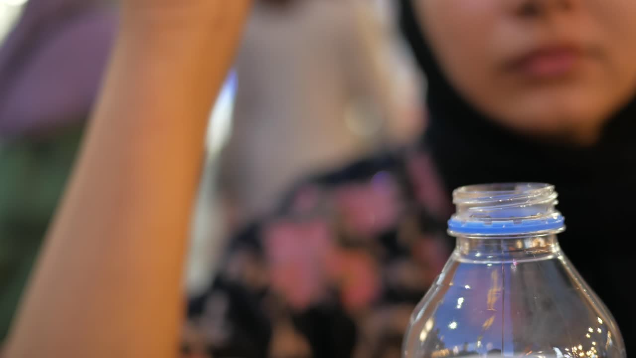 persona que abre una botella de agua