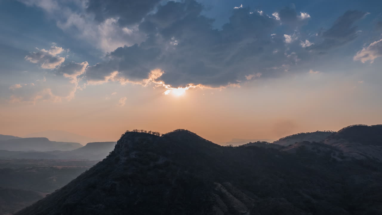 Rays of light rising through the clouds, illuminating the stunning mountain scenery in a light show.