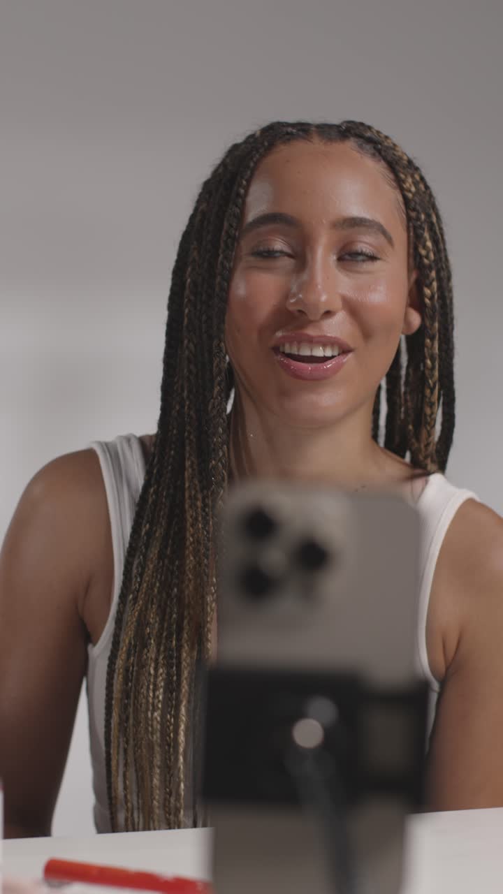 mujer joven grabando belleza maquillaje revisión o tutorial para lápiz labial en teléfono móvil para cargar en el canal de redes sociales