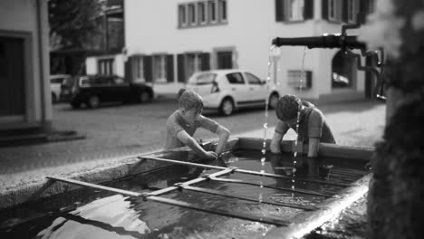 street fountain with statues in glarus, switzerland, highlighting a charming and artistic public landmark.