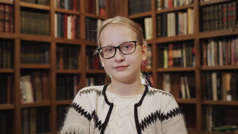 portrait of a student on the background of shelves with books in the library