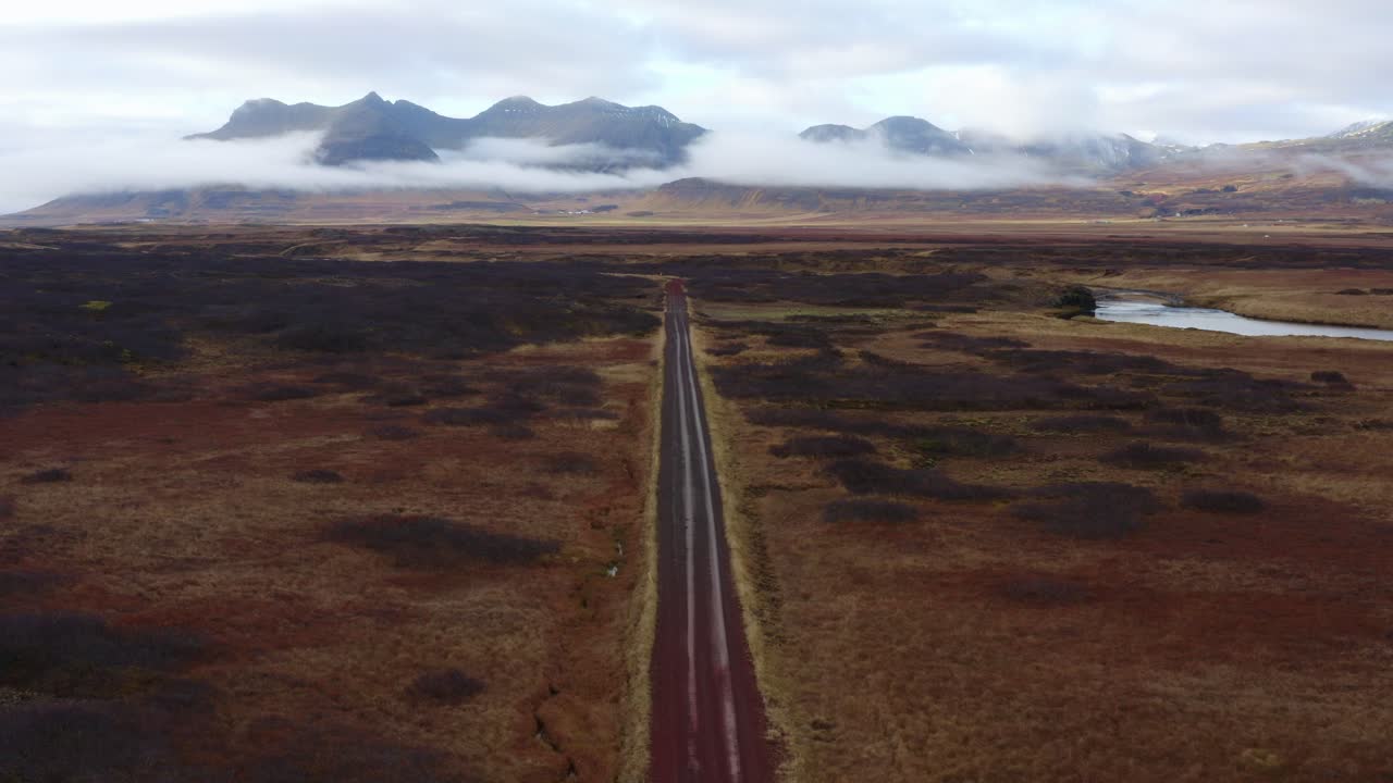 video de drones de revelación aérea de una carretera que atraviesa el desierto negro con una majestuosa cadena montañosa en el paisaje islandés: atracciones famosas y destinos emblemáticos en la naturaleza islandesa
