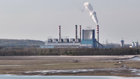 Konin-Poland-coal-power-plant-with-chimney-releasing-white-polluted-smoke-smog-co2-in-the-atmosphere-aerial-view