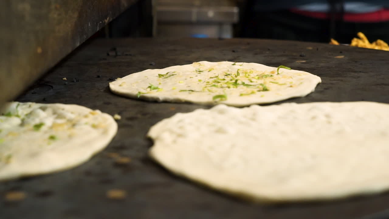 naan se tuesta en una plancha caliente en la cocina de un restaurante indio, el vapor se eleva desde el pan de fraternidad indio caliente, cierre en cámara lenta hd