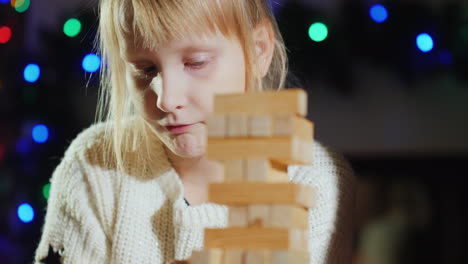 Girl-Pulls-Wooden-Blocks-From-The-Tower---A-Game-For-Training-Accuracy