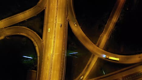 vista aérea vertical del tráfico en el cruce de la autopista por la noche. imágenes de 4k del dron
