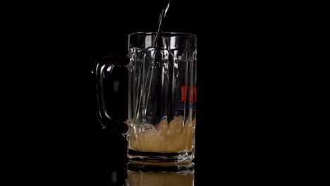 slow motion pouring beer in a glas, some drops are going wrong